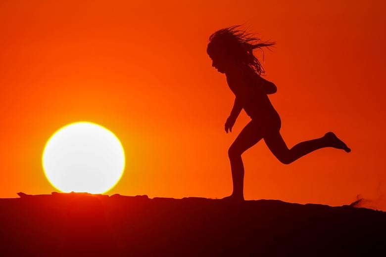 A child runs along the beach at sunset in Carlsbad, California. REUTERS/Mike Blake